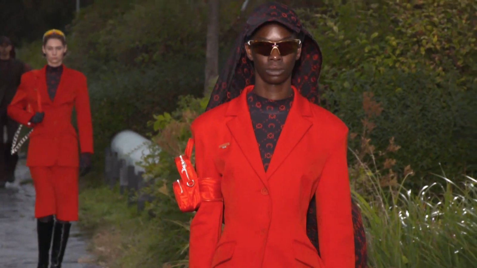 The show was staged on a rain-soaked embankment at the Auteuil racetrack, and all 600 guests were handed small black umbrellas.